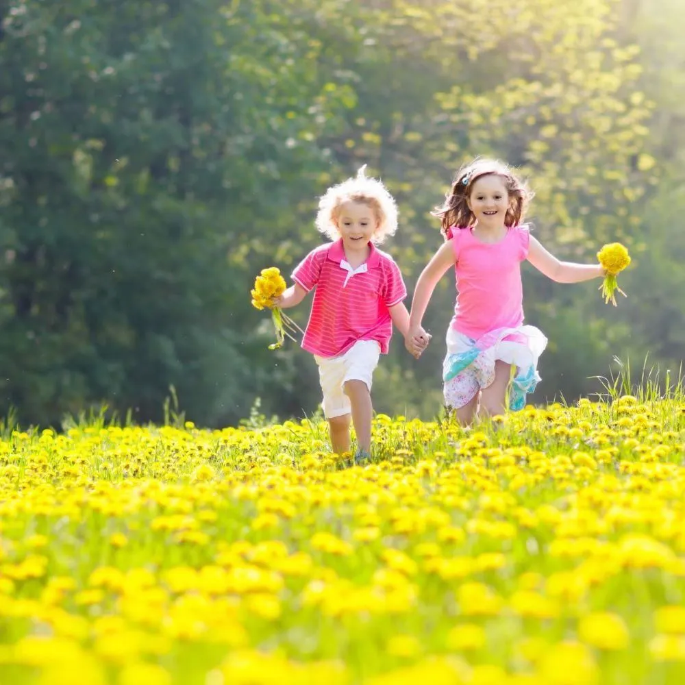 Deux enfants qui courent dans un champs pour illustrer le bonheur simple
